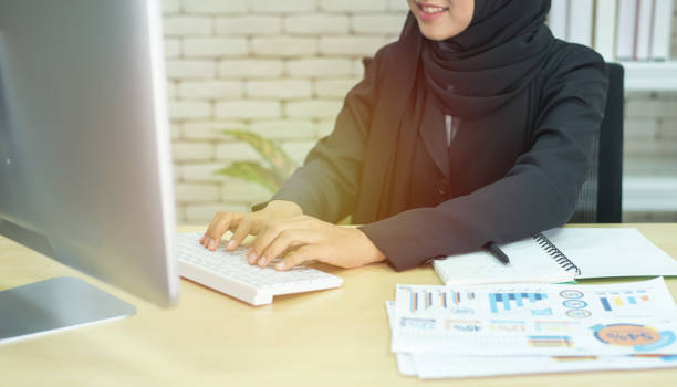 A Pakistani woman working on a laptop at home, symbolizing online entrepreneurship.