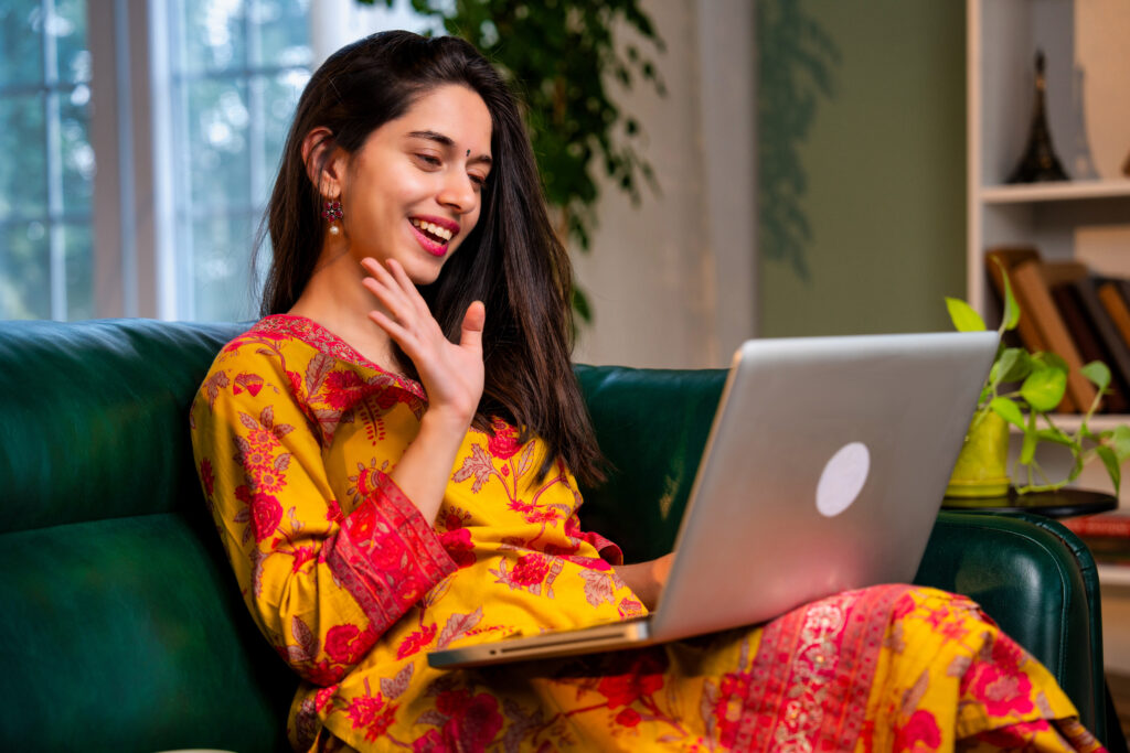 A Pakistani woman working on a laptop at home, symbolizing entrepreneurship.